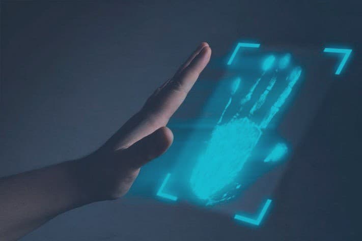 A hand hovering, untouched, above a palm vein scanner while the vein pattern beneath the skin is illuminated and captured.